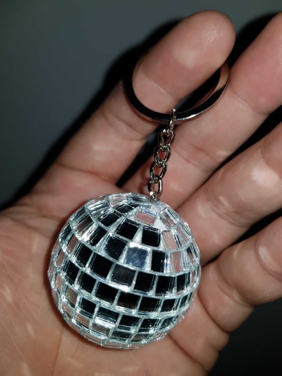 Chaveiro de mini globo espelhado na mão