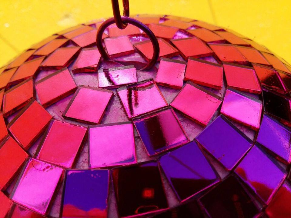 Detalhe dos espelhos de um globo espelhado rosa e roxo