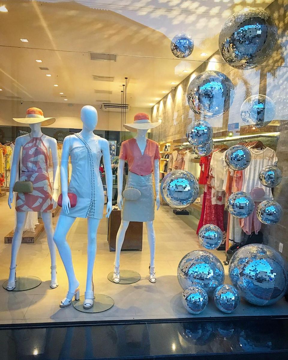 Vitrine de loja de roupas decorada com globos espelhados prata pendurados